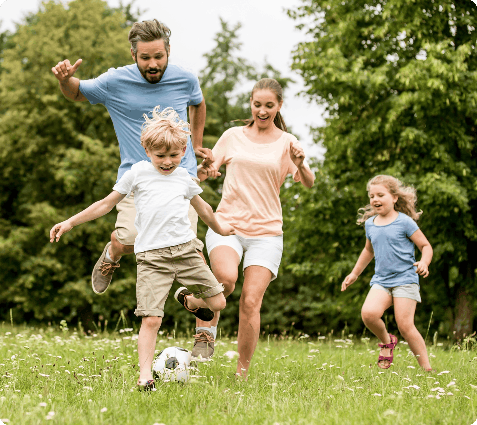 A family happily plays soccer together in a field A family happily plays soccer together in a field